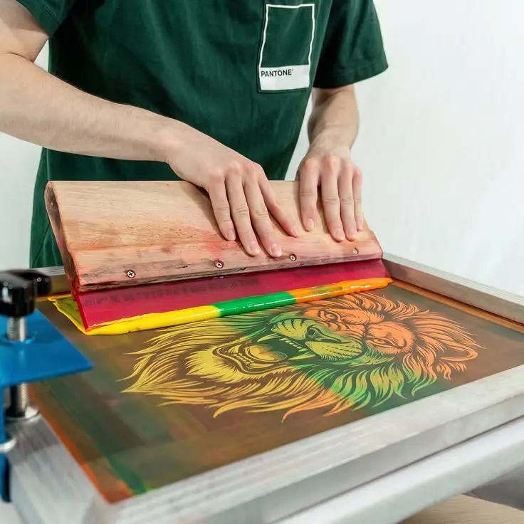 Screen printing process applying custom artwork to a cotton T-shirt