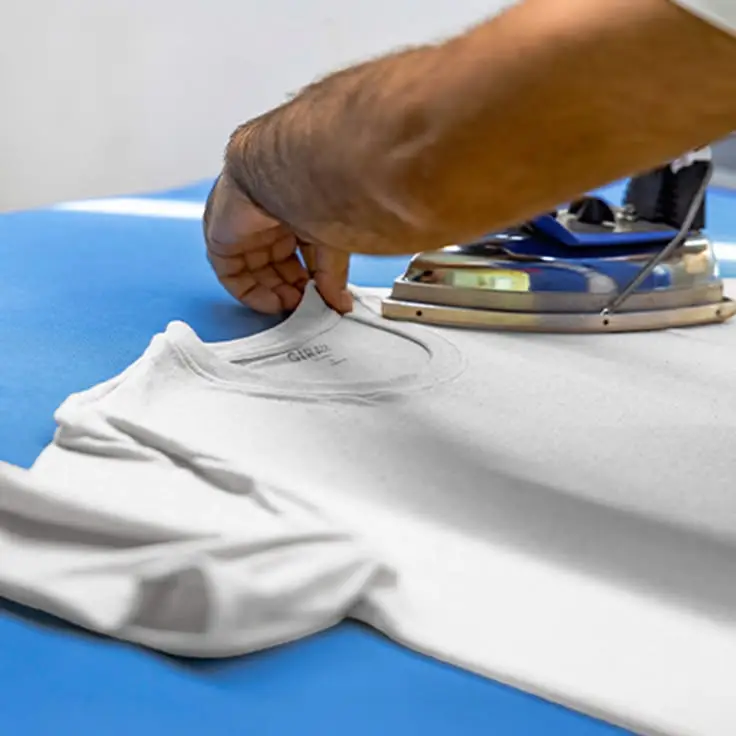 Finished garments being pressed, folded and prepared for export shipment after garment manufacturing